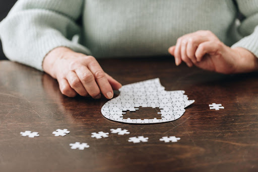 woman sitting in front of jigsaw puzzle in the shape of a head